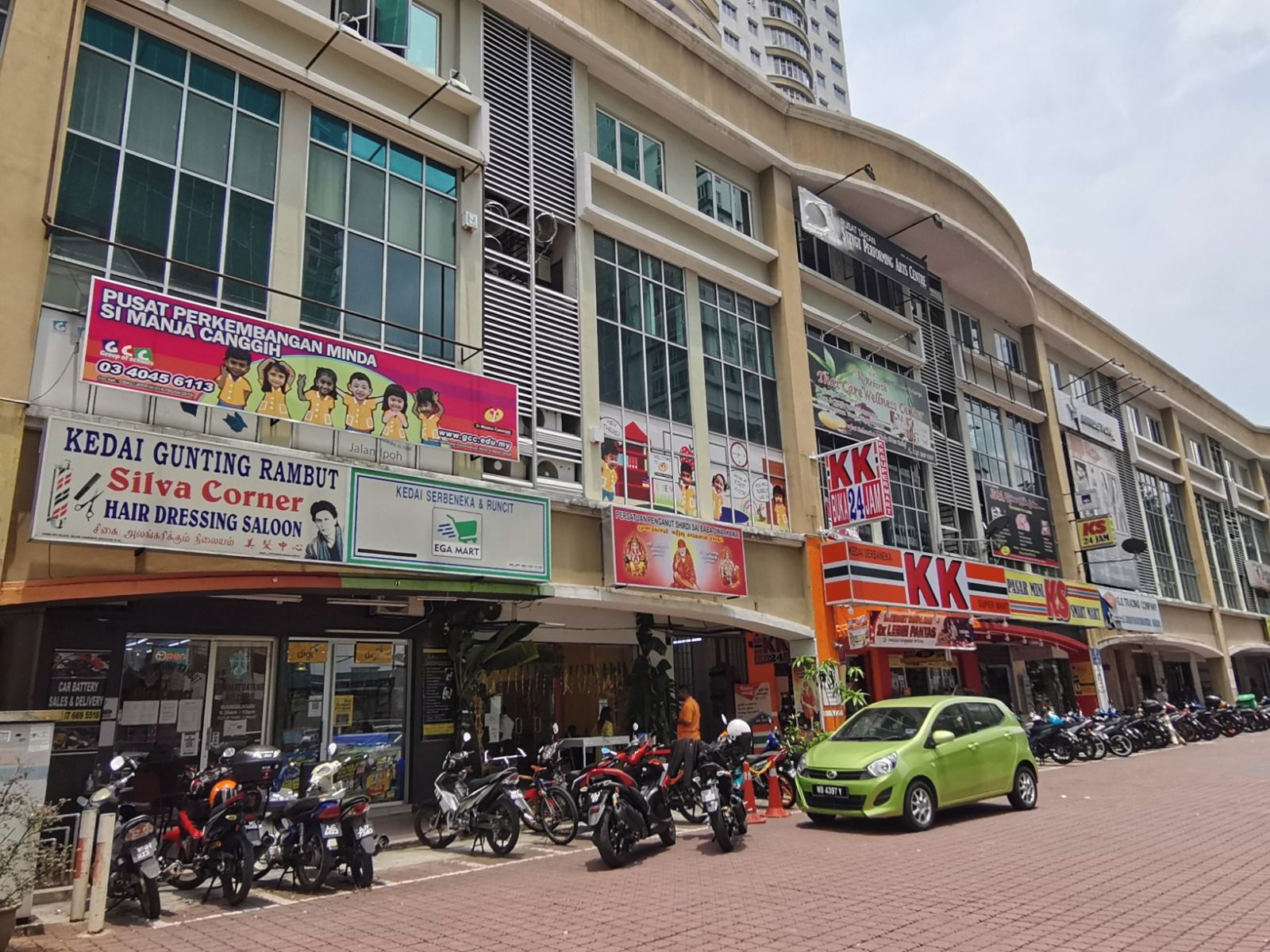 A commercial building with multiple storefronts, including a hairdressing salon and a convenience store.