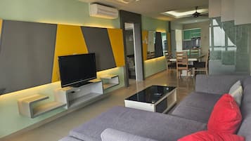 A modern living room with a flat-screen TV, a sofa, and a coffee table.
