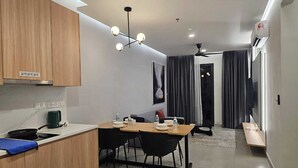 Una cocina moderna con armarios de madera, una mesa de comedor con sillas, un lámpara en el techo y un pequeño rincón de kitchenette.