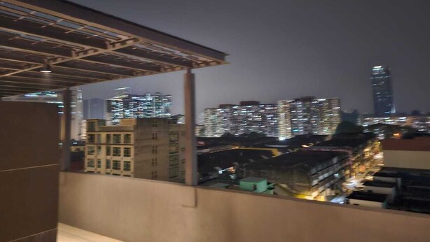 Un paisaje urbano nocturno con rascacielos y vistas del área metropolitana.