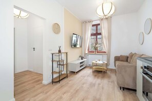Ein modernes Wohnzimmer mit einer Couch, einem Couchtisch und einem an der Wand befestigten Fernseher.