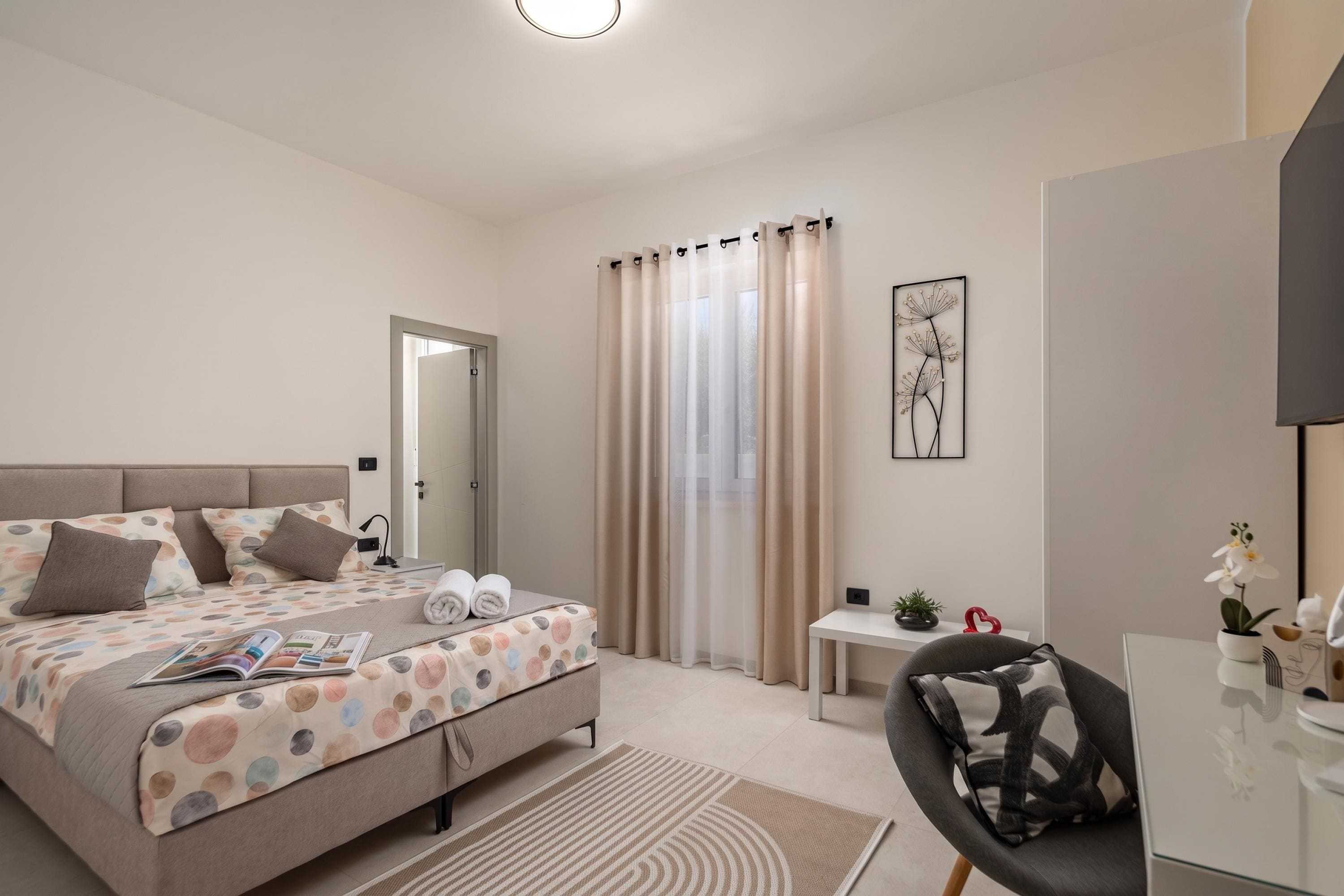A modern bedroom with a bed, a desk, and a chair.
