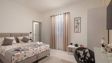 Quarto moderno com cama, escrivaninha e cadeira.