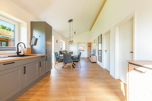 A modern kitchen with grey cabinets, a wooden countertop, and a built-in oven. - Accessible vacation home "Huus Bodderbloom" in Kating for up to 4 people (Kating)