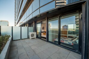 Een modern gebouw met balkon, grote ramen en een airconditioner.