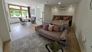 A modern bedroom with a double bed, a sofa, and a desk area. - Rebstock Apartment in the wine-growing region of Baden-Baden. (Baden-Baden)