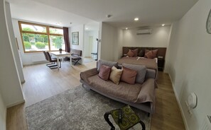 A modern bedroom with a double bed, a sofa, and a desk area. - Rebstock Apartment in the wine-growing region of Baden-Baden. (Baden-Baden)