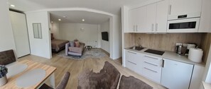 A modern kitchen with white cabinets and a built-in oven. - Rebstock Apartment in the wine-growing region of Baden-Baden. (Baden-Baden)