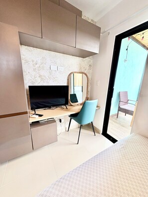 A bedroom with a bed, a desk with a computer, a chair, and a large mirror. - Cozy studio in gated community near Downtown Punta Cana (Punta Cana)
