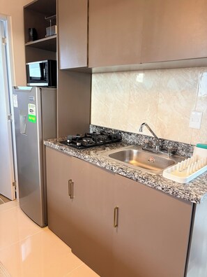 A modern kitchen with stainless steel appliances, a granite countertop, and a built-in sink. - Cozy studio in gated community near Downtown Punta Cana (Punta Cana)