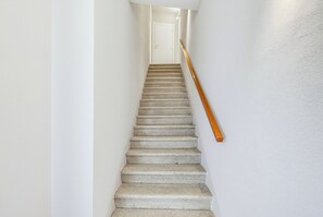 A staircase with a wooden handrail leading to a white door at the top. - Il Giardino di Rosa e Gli Olivi di Rosa (Lavaiano)