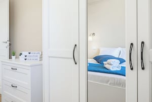 Un dormitorio con cama, mesita de noche, cómoda y espejo.