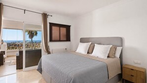 A bedroom with a bed, a nightstand, a window, and a view of the outdoors. - RDR576 - Sea Views 2 Bed Apartment in Sea&Sun Hills (Estepona)
