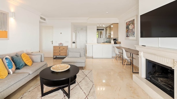 A modern living room with a sofa, a coffee table, and a fireplace. - RDR576 - Sea Views 2 Bed Apartment in Sea&Sun Hills (Estepona)