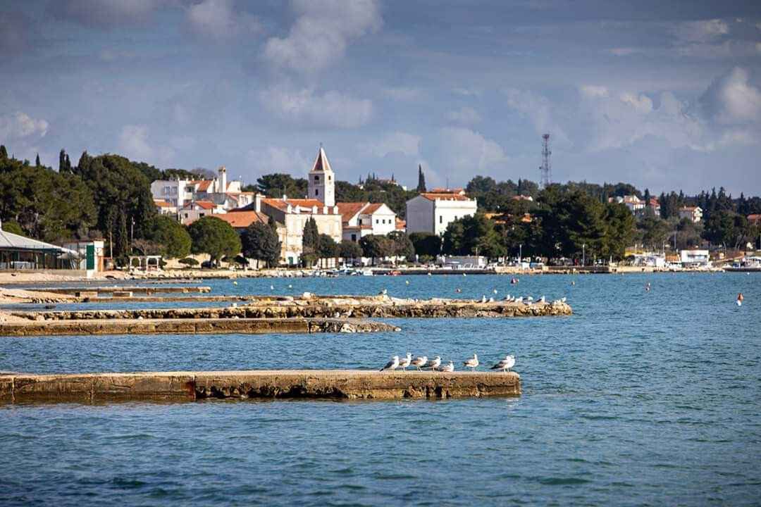 En kystby med en markant kirke, en promenade langs vandet og klippefyldte havneanlæg.