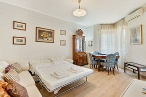 A hotel room with a bed, a desk, and a chair. There are framed pictures on the wall. - [CasettaDellePunte]Road to lerici-Air conditioning (Romito Magra)