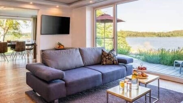 Ein modernes Wohnzimmer mit einer Couch, einem Couchtisch und einem an der Wand befestigten Fernseher.