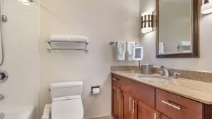 Een badkamer met toilet, wastafel en spiegel.