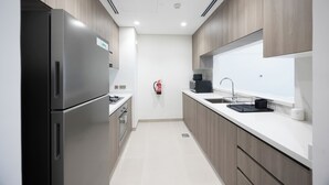 Una cocina moderna con electrodomésticos de acero inoxidable, horno empotrado y un amplio ventanal sobre el fregadero.