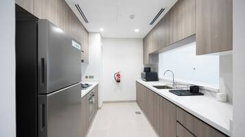 A modern kitchen with stainless steel appliances, a built-in oven, and a large window above the sink.