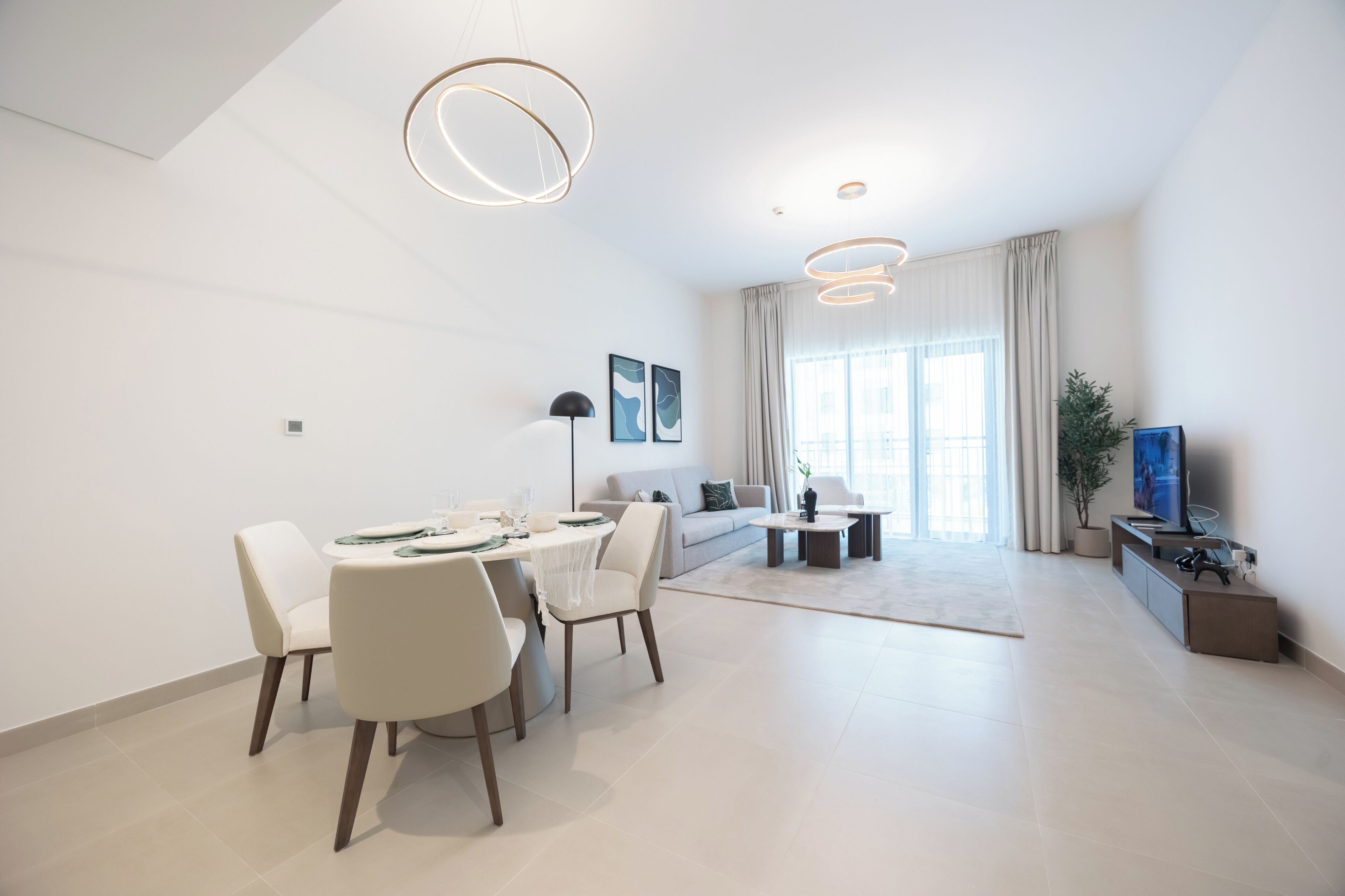 Una sala de estar moderna con comedor, un sofá, una mesa de centro y un televisor.