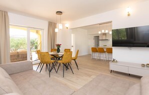 A modern living room with a dining area, a kitchen, and a TV mounted on the wall. - Beautiful home in Biograd na Moru (Biograd na Moru)