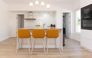 A modern kitchen with a central island, three bar stools, a built-in oven, and pendant lighting. - Beautiful home in Biograd na Moru (Biograd na Moru)