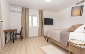 A hotel room with a bed, a desk, a chair, a television, and a window. - Beautiful home in Biograd na Moru (Biograd na Moru)