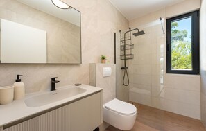 A modern bathroom with a large mirror, a sink with a black faucet, a toilet, and a shower with a glass enclosure. - Villa Olive Tree Pridraga (Pridraga)