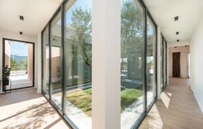 A modern interior with large glass doors leading to a garden. - Villa Olive Tree Pridraga (Pridraga)