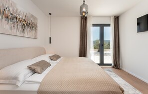 A bedroom with a bed, a painting, a pendant light, and a view through a glass door. - Villa Olive Tree Pridraga (Pridraga)