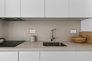 A kitchen with a stainless steel sink, a wooden cutting board, a white ceramic jar, and a black mat. - Casa Set - Private Pool Villa - 5 min to the Beach (A dos Cunhados)
