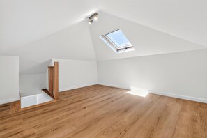 A room with a sloped ceiling, a skylight, and wooden flooring. - Casa Set - Private Pool Villa - 5 min to the Beach (A dos Cunhados)