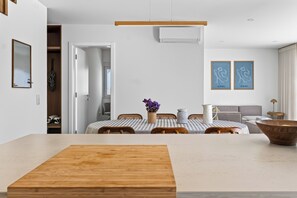 A modern dining area with a wooden table, chairs, and a vase with flowers. - Casa Set - Private Pool Villa - 5 min to the Beach (A dos Cunhados)