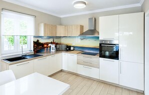 A modern kitchen with a large window, a built-in oven, and a cityscape backsplash. - Stunning home in Porec (Porec)