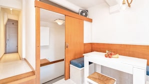 A compact kitchen with a white countertop, a wooden cabinet, and a small seating area. - [FinestraNelBorgo] 5Terre-Portovenere-Seaview (Porto Venere)