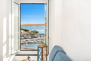 A balcony with a view of a marina, boats, and a distant mountain. - [FinestraNelBorgo] 5Terre-Portovenere-Seaview (Porto Venere)