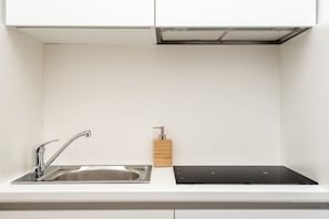 A modern kitchen with a stainless steel sink, a black countertop, and a wooden soap dispenser. - [FinestraNelBorgo] 5Terre-Portovenere-Seaview (Porto Venere)