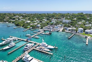 A marina with multiple docks and yachts, surrounded by residential buildings and lush greenery.