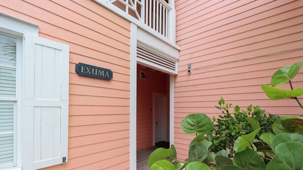 A building with a sign reading 'EXUMA' and a white door.