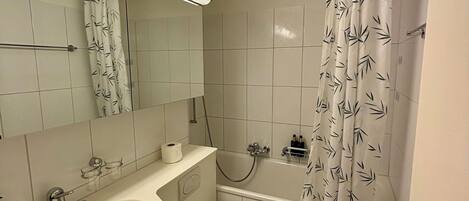A bathroom with a sink, toilet, and bathtub.