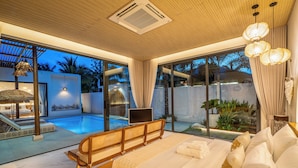 Quarto moderno com uma cama grande, vista para uma piscina e porta de vidro que dá para uma área externa.