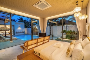A modern bedroom with a large bed, a view of a swimming pool, and a glass door leading to an outdoor area. - Westkey Luxury Villa (Kathu)