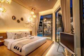 Quarto de hotel moderno com uma cama grande, televisão e vista para uma piscina.