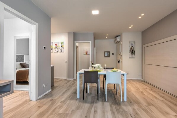 A modern interior with a dining area, a kitchen, and a bedroom.
