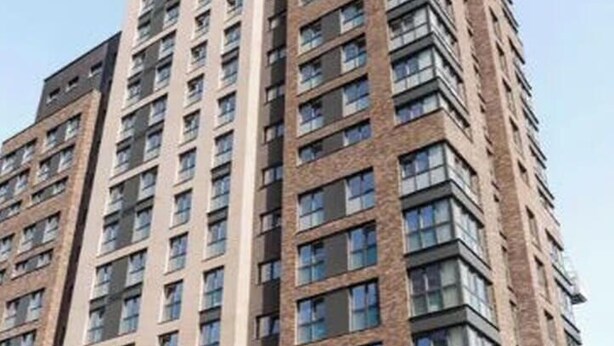 Un edificio a più piani con facciata in mattoni e ampie finestre.
