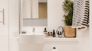 Un bagno moderno con cabina doccia in vetro, lavabo bianco e water.