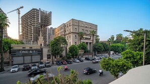 Um edifício de vários andares com um amplo estacionamento e uma grua de construção ao fundo.