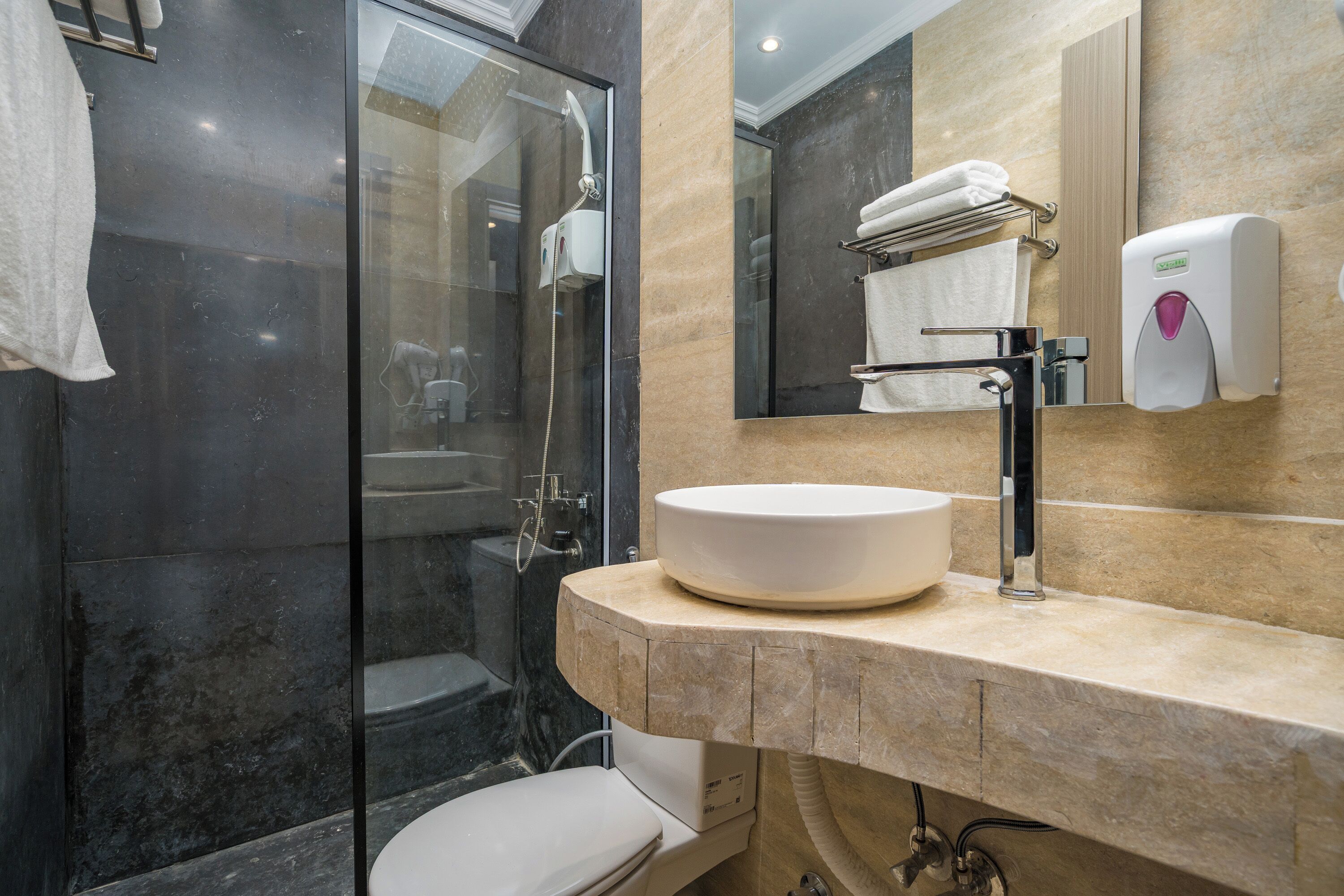 A modern bathroom with a glass-enclosed shower, a white sink, and a large mirror.