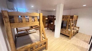 Ein Zimmer mit Stockbetten, einem Kleiderschrank und einem Spiegel.